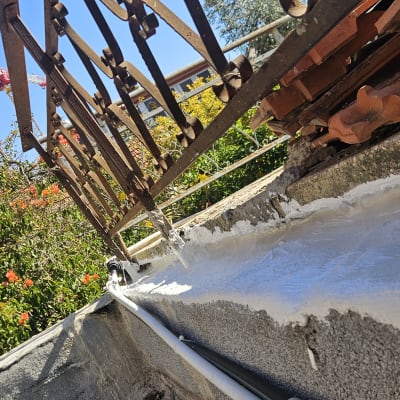 איטום גג עם חומר לבן ליד מעקה ברזל