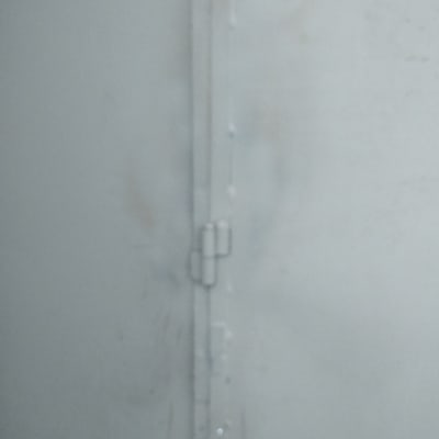 ציר מתכת על דלת מתכת אפורה