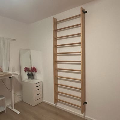 סולם עץ מותקן על קיר בחדר עם רצפת עץ