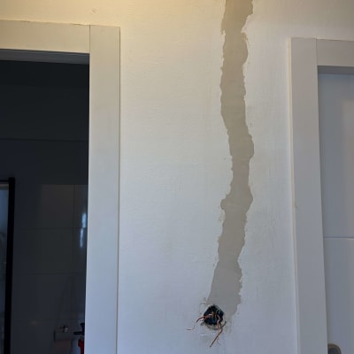 חוטי חשמל יוצאים מקיר עם חור