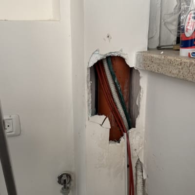 צינורות חשופים בקיר עם חור ותשתית אינסטלציה