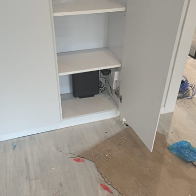ארון פתוח עם ציוד תקשורת וחוטים על הרצפה