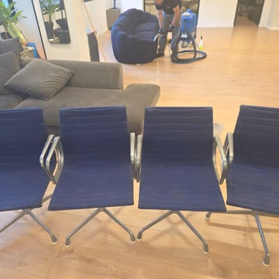 בעל מקצוע מנקה ספת בד כחולה באמצעות מכונת ניקוי מקצועית