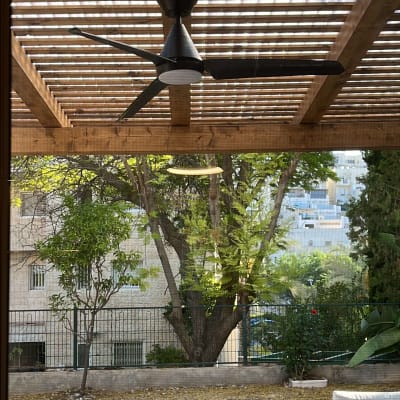 מאוורר תקרה תחת פרגולה מעץ בחצר
