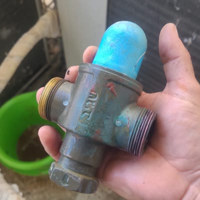 שסתום מתכת עם כיסוי כחול ביד אדם