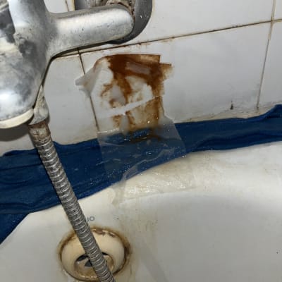 דליפת מים וחלודה בקיר סמוך לברז אמבטיה לפני תיקון