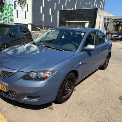 רכב כחול חונה בחניון ליד מכונית שחורה