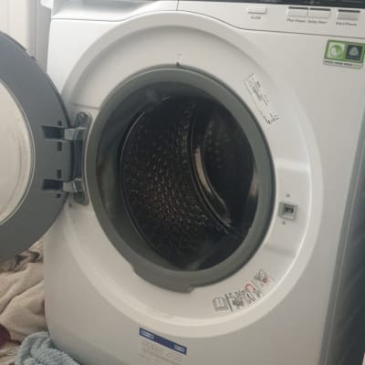 מכונת כביסה עם דלת פתוחה ולוח בקרה