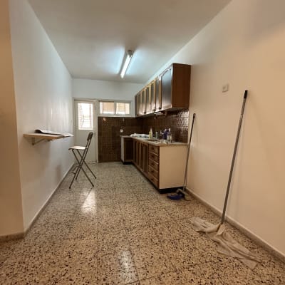 מטבח עם קירות צבועים וכלי ניקוי על הרצפה