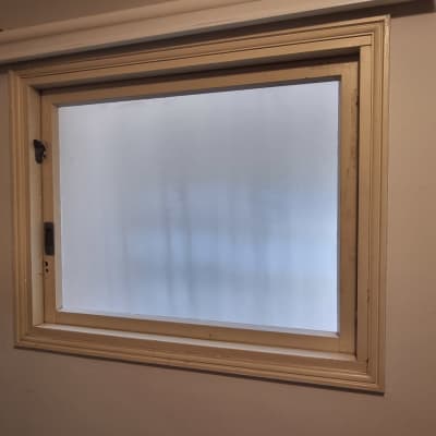 חלון זכוכית עם מסגרת עץ על קיר פנימי