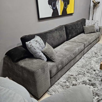 ספה אפורה עם כריות על שטיח רך