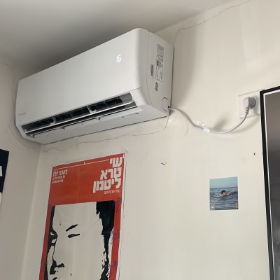 מזגן מותקן על קיר עם כבל חשמל מחובר