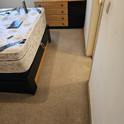 חדר שינה עם מזרן על מיטה, שטיח על הרצפה