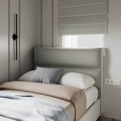 מיטה עם מצעים אפורים וכרית דקורטיבית