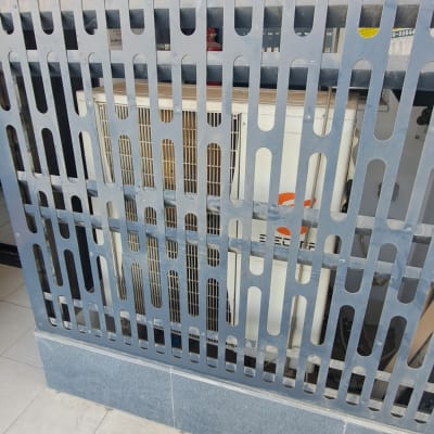 יחידת מיזוג אוויר מאחורי גדר מתכת על מרפסת