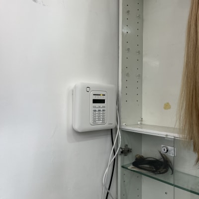 לוח מקשים לבן מותקן על קיר ליד ארון זכוכית