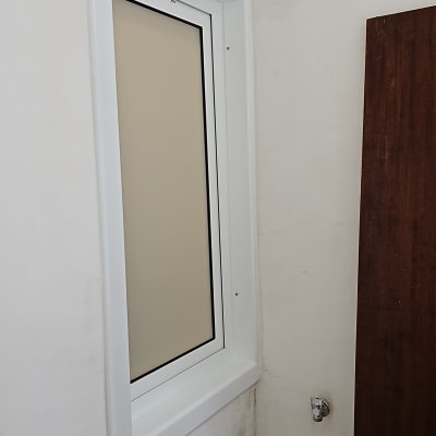 חלון אלומיניום עם מסגרת לבנה בקיר לבן