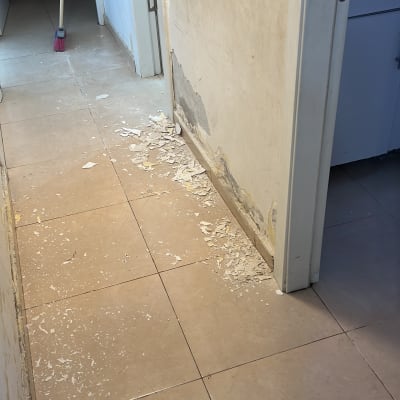 קיר מתקלף עם שאריות צבע על הרצפה