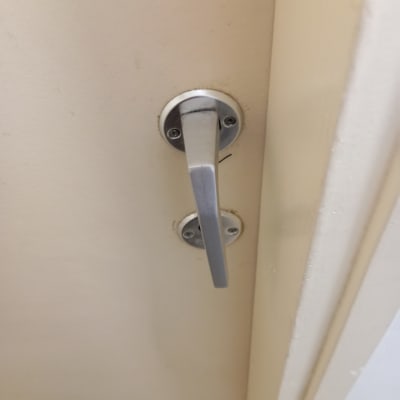 ידית דלת מתכתית על דלת עץ