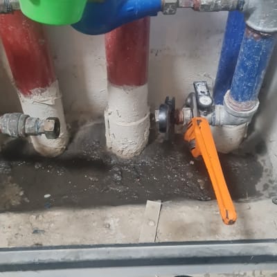 מד מים כחול עם מכסה ירוק, מפתח צינורות כתום