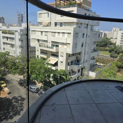 מעקה זכוכית במרפסת עם נוף לעיר