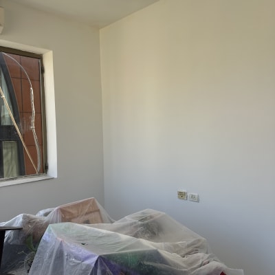 חדר עם קירות צבועים, רהיטים מכוסים בניילון