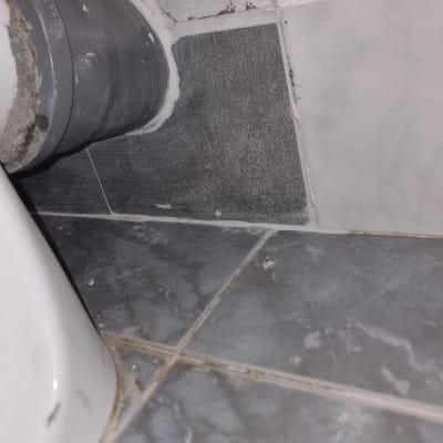 צינור אפור מחובר לקיר עם אריחים אפורים