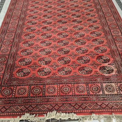 שטיח אדום עם דוגמאות גיאומטריות על רצפה אפורה