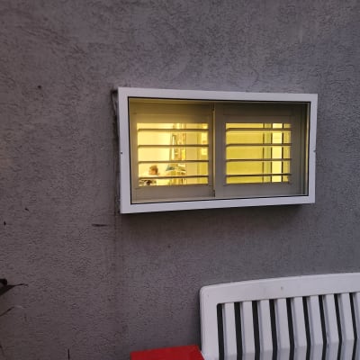 חלון אלומיניום עם תריסים על קיר אפור