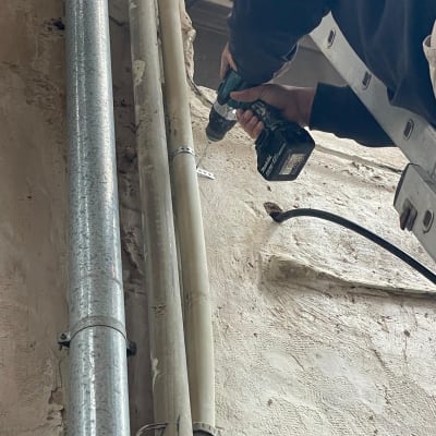 עבודה עם מקדחה על צינורות קיר