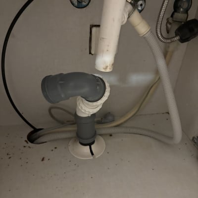 צנרת מתחת לכיור עם חיבורים וצינורות פלסטיק