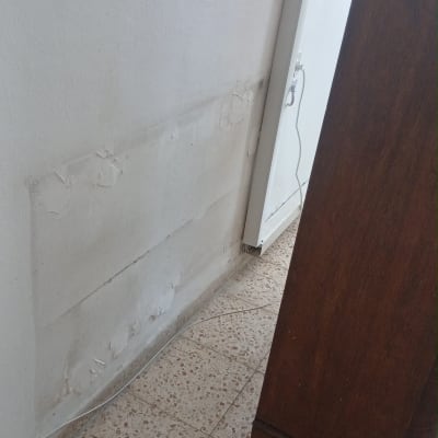 קיר עם סימני תיקון ליד רהיט
