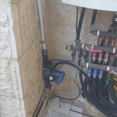 מערכת השקיה עם צינורות וברזים על קיר אבן