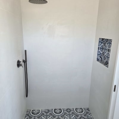 מקלחת עם אריחים מעוצבים וראש מקלחת מודרני