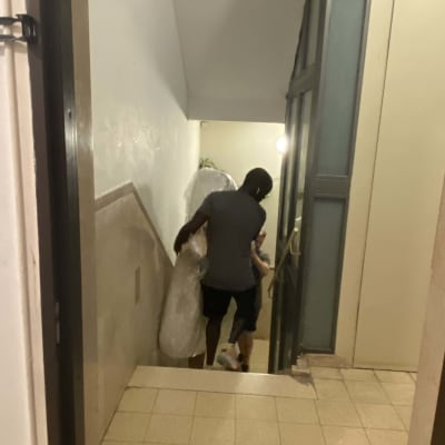 אדם נושא חפץ עטוף במדרגות