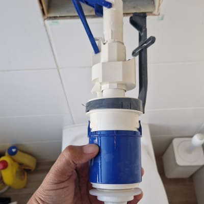 יד מחזיקה חלק של אסלה בשירותים