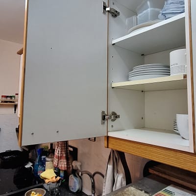 ארון מטבח פתוח עם כלים וסכו"ם בכיור