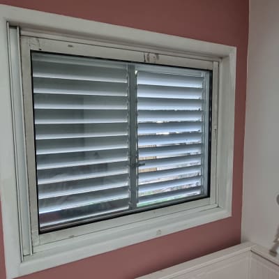 חלון עם תריסים סגורים על קיר ורוד