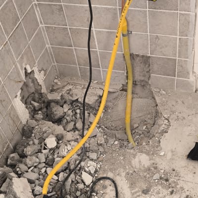 עבודות גז עם צינורות וכלים על רצפה שבורה