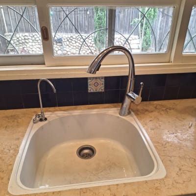 כיור מטבח עם ברזים נירוסטה ומים זורמים