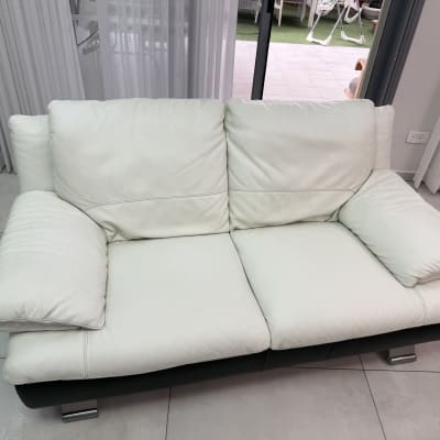 ספה לבנה נקייה עם רגלי מתכת על רצפה בהירה