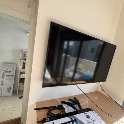 טלוויזיה מותקנת על קיר עם כלים על שולחן