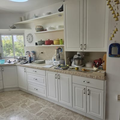 מטבח עם ארונות לבנים, מיקסר וכלים על השיש