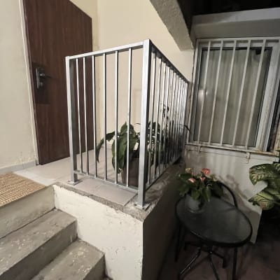 מעקה מתכת ליד דלת וחלון עם סורגים