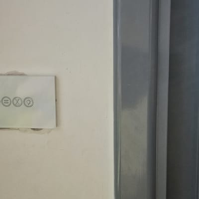 מתג חשמלי על קיר ליד חלון עם תריסים