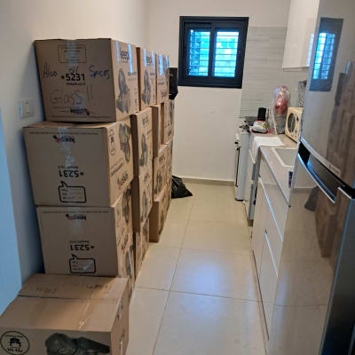 ארגזים מסודרים במטבח קטן עם מקרר וכיור