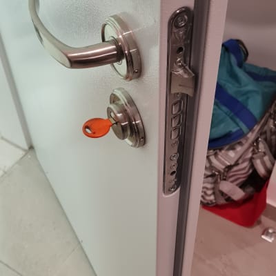 דלת עם ידית מתכת ומנעול עם מפתח כתום