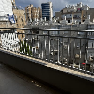 מעקה מרפסת עם נוף לבניינים ברקע