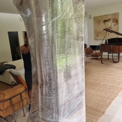 אדם עוטף רהיט בניילון לקראת מעבר דירה