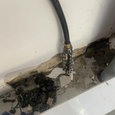 צינור שחור מחובר לקיר עם שרשרת מתכת